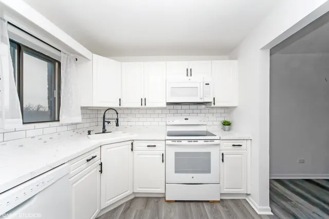 a kitchen with cabinets appliances a sink and a counter top