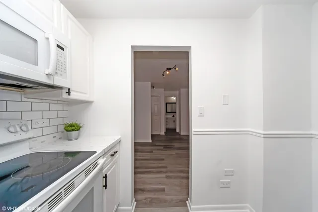 a kitchen with a refrigerator and white cabinets