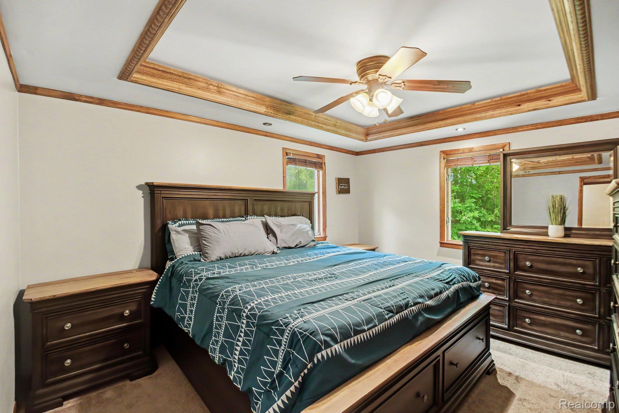 1646 Boy Scout Road Caro, MI 48723 - Photo 10 of 28 Spacious room featuring a tray ceiling with wood-finish trim, multiple windows with natural light, and a ceiling fan