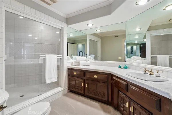 a large white kitchen with kitchen island a refrigerator a stove a sink dishwasher and a dining table with wooden floor
