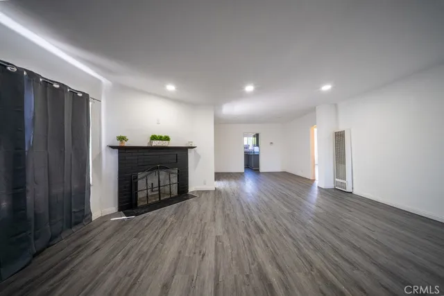 a view of empty room with a fireplace and window
