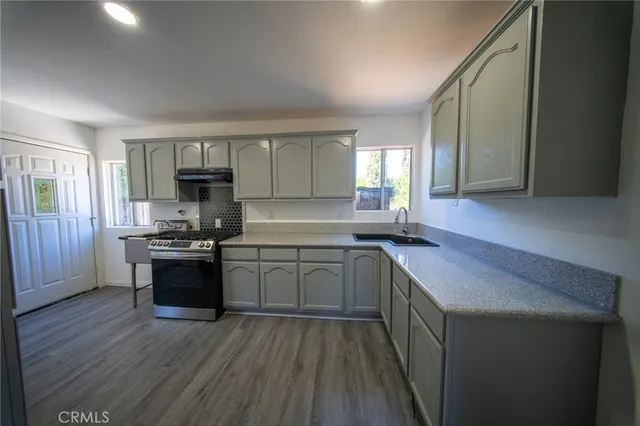 a kitchen with a sink stove top oven and cabinets