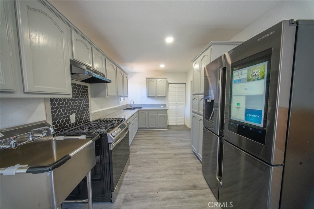 843 West Brazil Street Compton, CA 90220 - Photo 4 of 17 a kitchen with a sink a refrigerator and a stove top oven