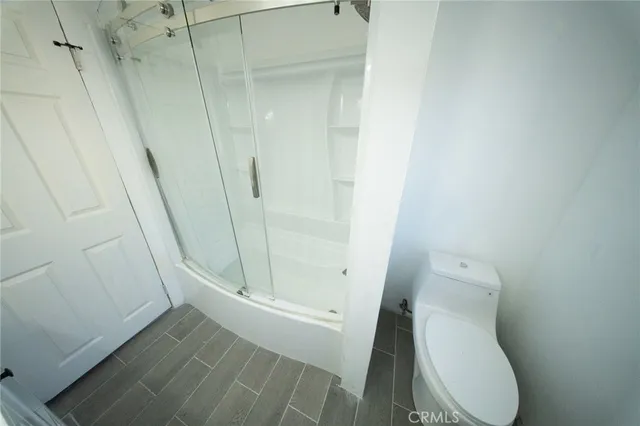 a white toilet sitting next to a shower