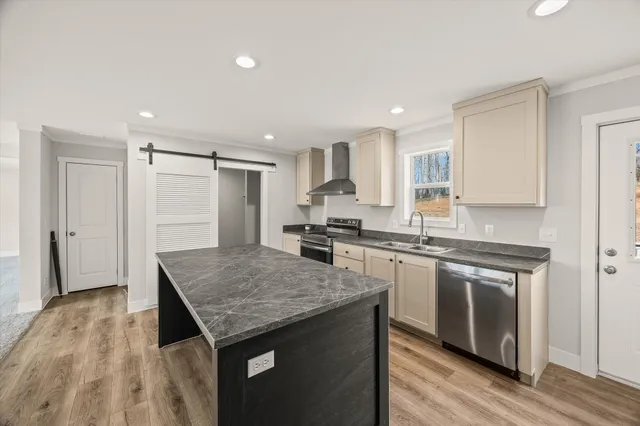 a kitchen with stainless steel appliances granite countertop a sink stove and refrigerator