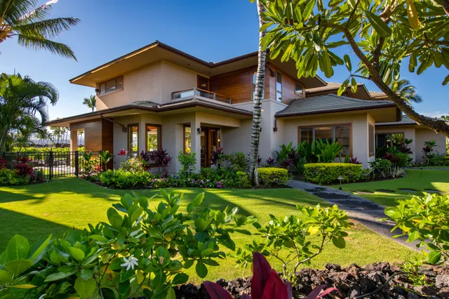 a front view of a house with a yard and potted plants