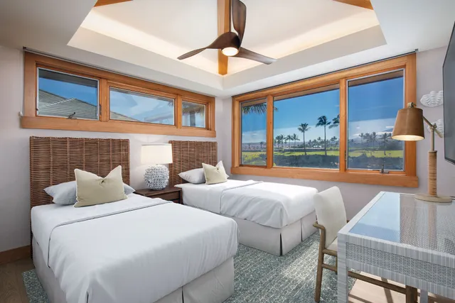 a bedroom with two large bed and a large window