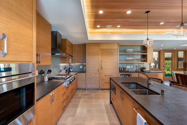 a kitchen with stainless steel appliances granite countertop a sink a stove and a wooden floors