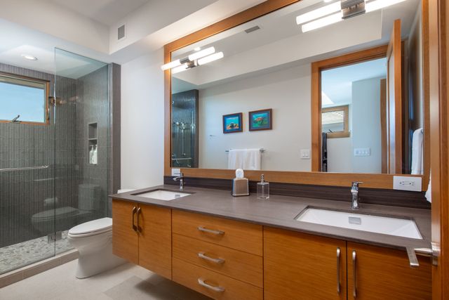 a bathroom with double vanity and a mirror