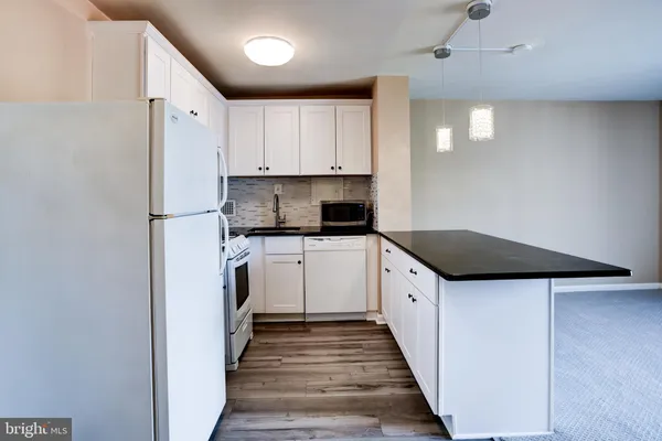 a kitchen with white cabinets and white appliances