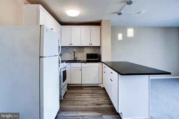 a kitchen with white cabinets and white appliances