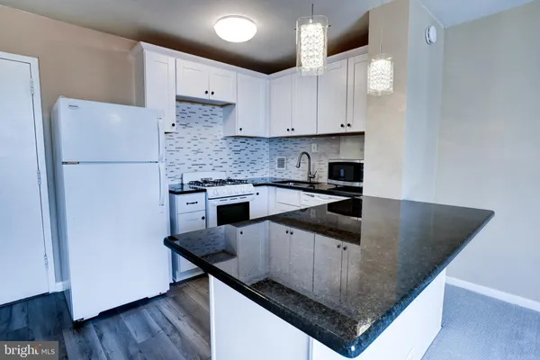 a kitchen with stainless steel appliances granite countertop a sink a stove and a refrigerator