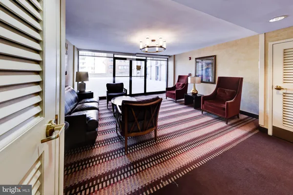 a living room with furniture a large window and a rug