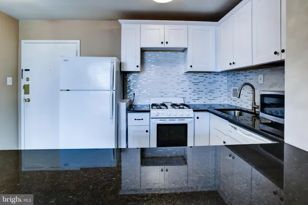 a kitchen with stainless steel appliances granite countertop a stove a refrigerator and a stove