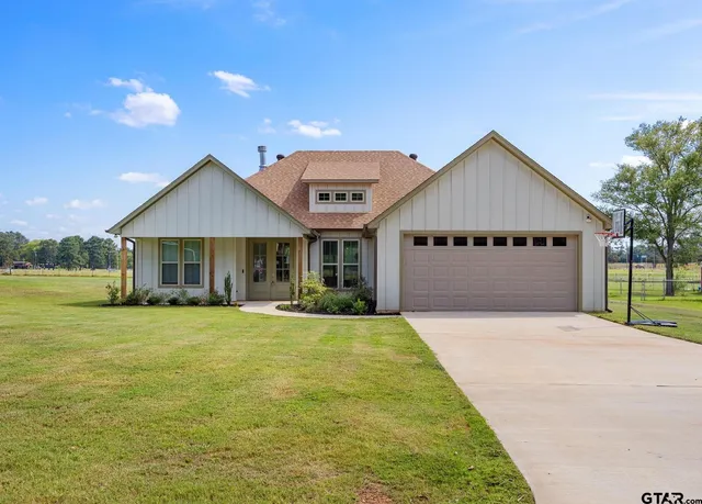 a front view of a house with a garden and yard