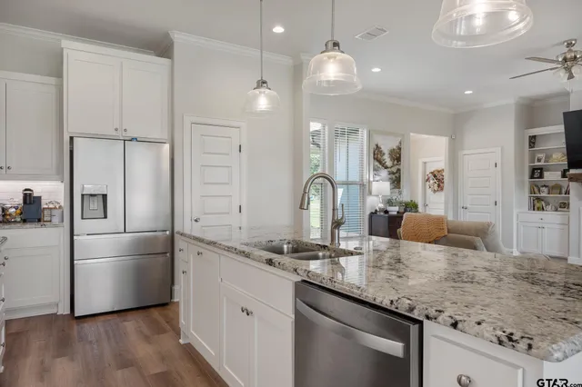 a kitchen with granite countertop a sink appliances cabinets and counter space