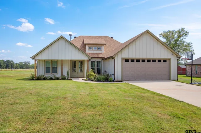a front view of a house with a garden and yard