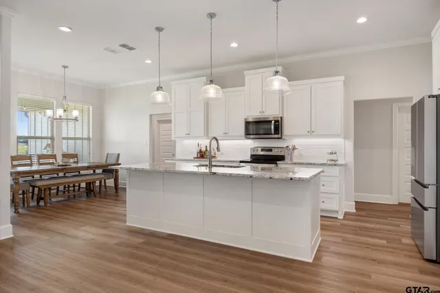 a large kitchen with kitchen island a sink a center island stainless steel appliances and a center island