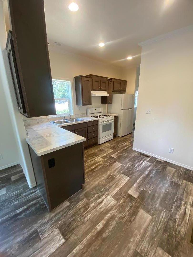 6165 Pony Express Trail, Unit 32 Pollock Pines, CA 95726 - Photo 5 of 7 a large kitchen with stainless steel appliances granite countertop a stove a sink and a microwave
