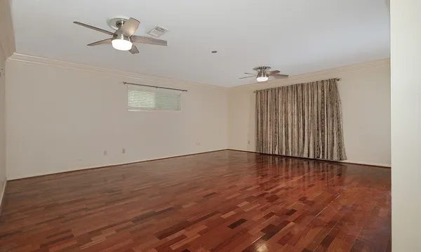 a view of an empty room with wooden floor
