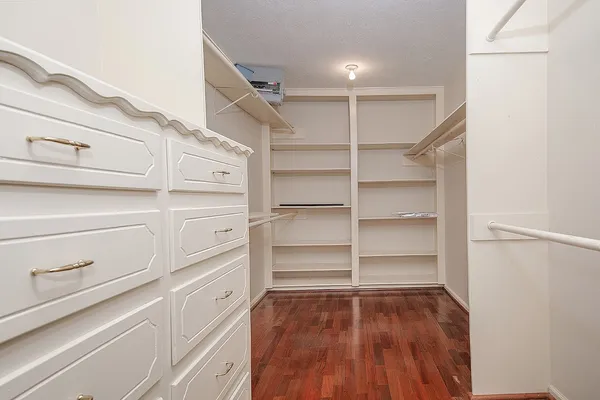 a view of walk in closet with empty racks