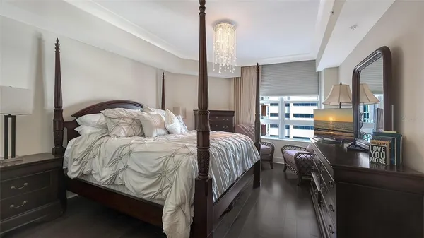 a bedroom with a bed and dresser with mirror