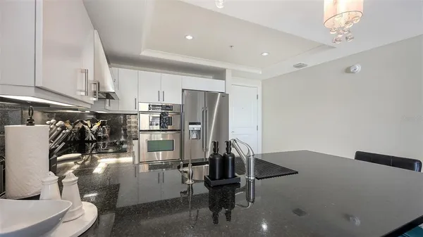 a view of a kitchen with refrigerator and workspace