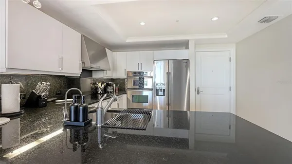 a kitchen with stainless steel appliances granite countertop a refrigerator and a stove top oven