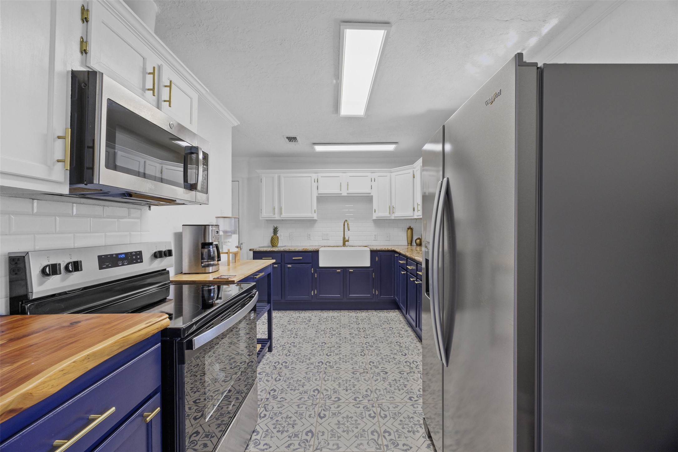 5874 Beldart Street Houston, TX 77033 - Photo 11 of 37 Kitchen equipped with a newer flat-top stove, microwave, and ample prep space for everyday cooking.