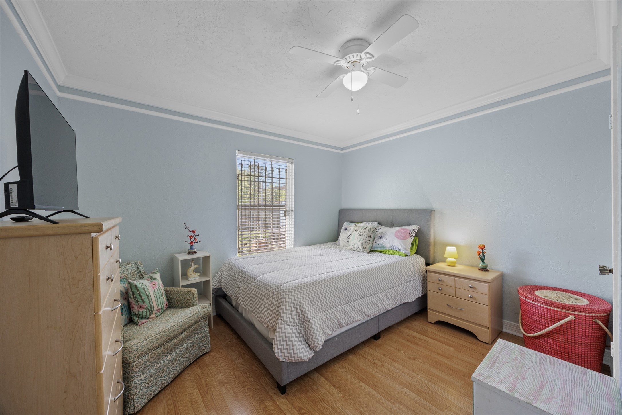 5874 Beldart Street Houston, TX 77033 - Photo 16 of 37 First secondary bedroom with natural light, laminate flooring, and a comfortable layout; a second bedroom is located just next door.