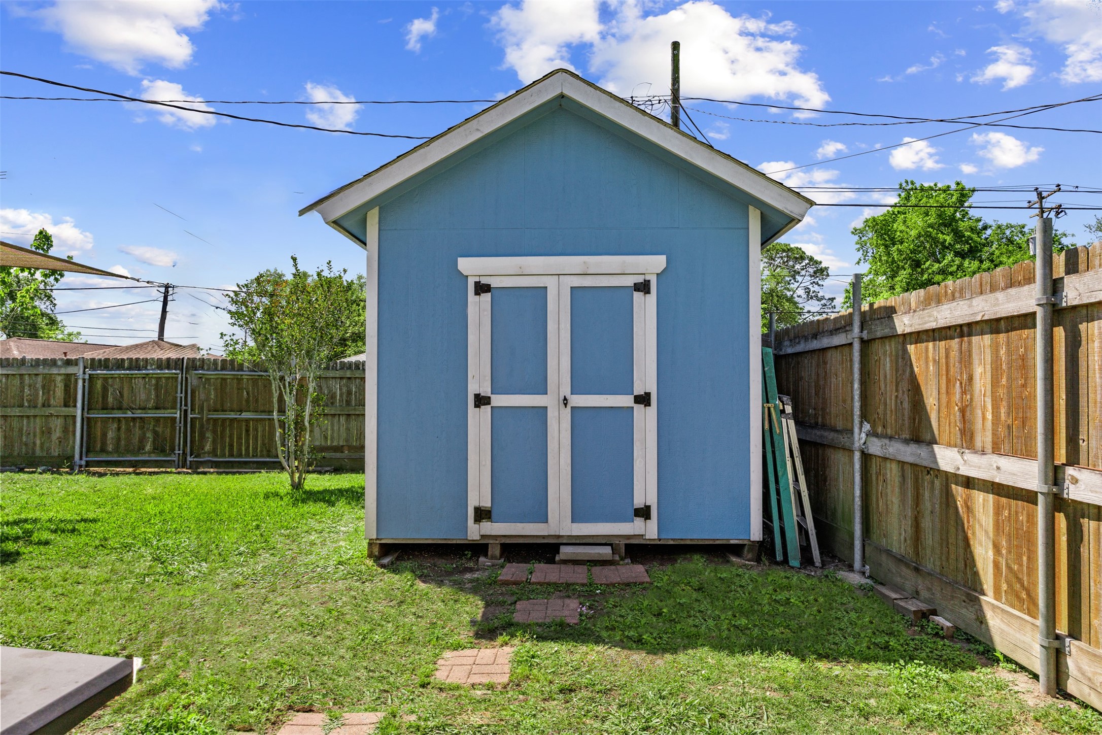 5874 Beldart Street Houston, TX 77033 - Photo 21 of 37 Storage shed in the backyard designed to match the home—perfect for tools, equipment, or extra storage.
