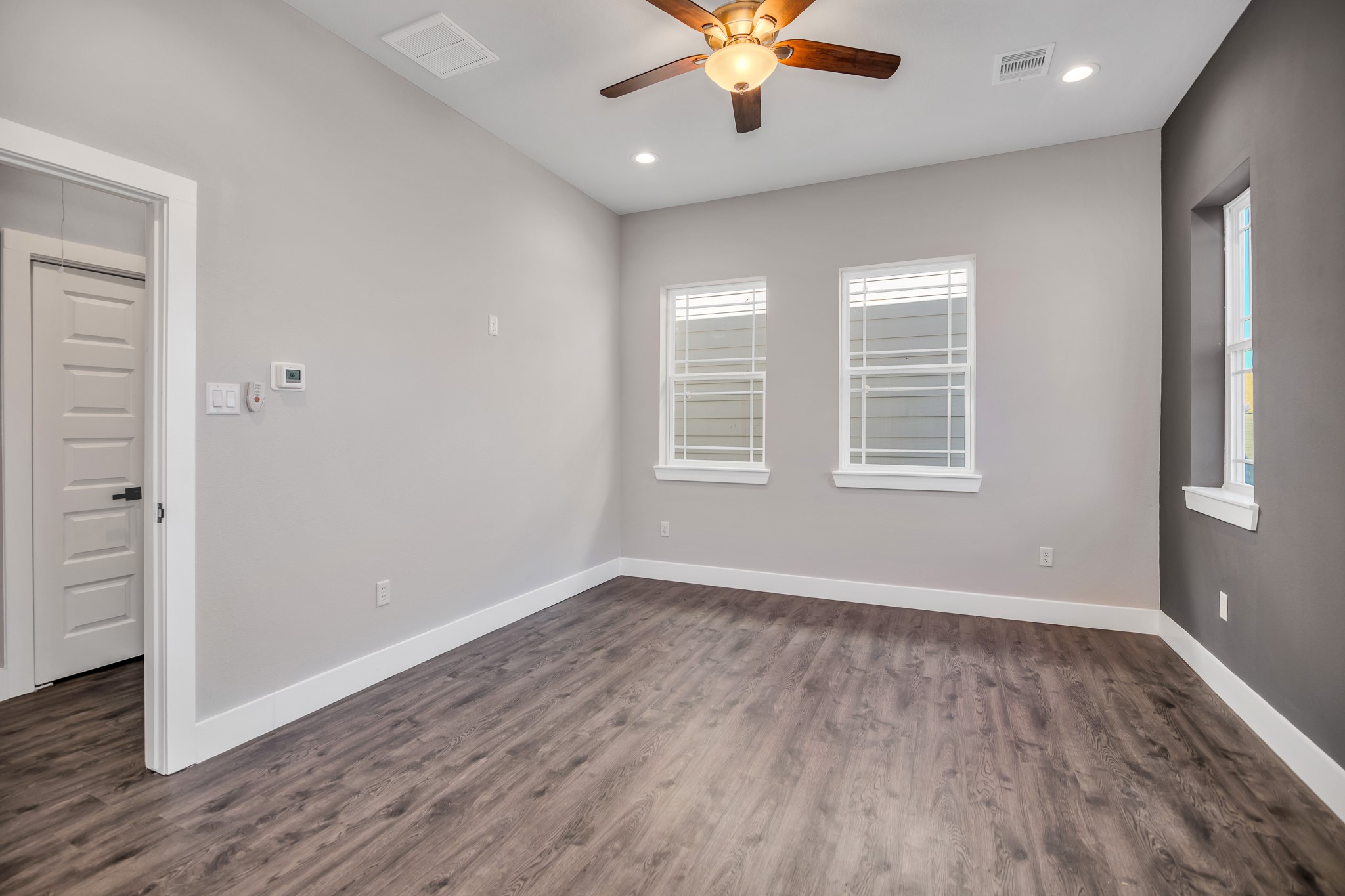4924 Winnetka Street, Unit A Houston, TX 77021 - Photo 17 of 26 an empty room with wooden floor chandelier fan and windows