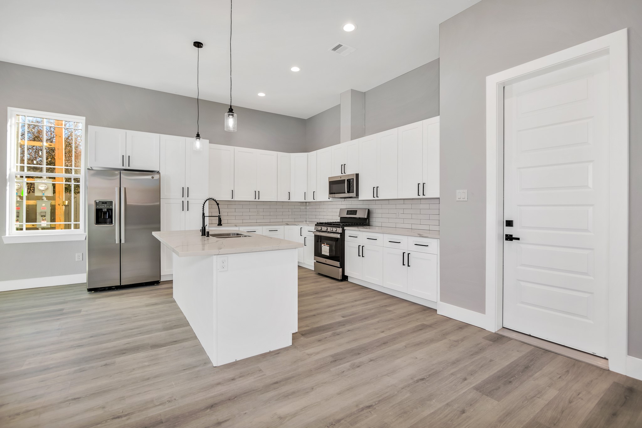 4924 Winnetka Street, Unit A Houston, TX 77021 - Photo 8 of 26 a kitchen with wooden floors and white cabinets