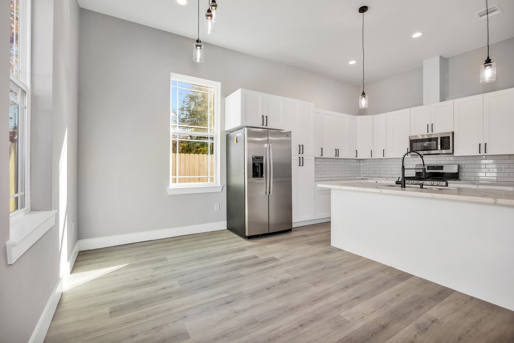4924 Winnetka Street, Unit A Houston, TX 77021 - Photo 10 of 26 a kitchen with stainless steel appliances granite countertop a refrigerator a sink dishwasher a stove and white countertops with wooden floor
