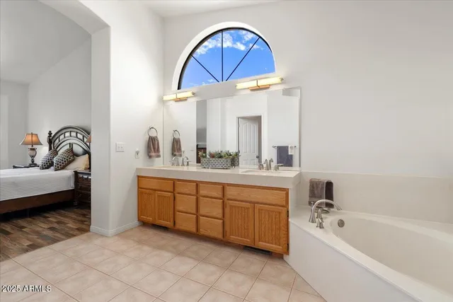 a bathroom with a tub a sink and a mirror