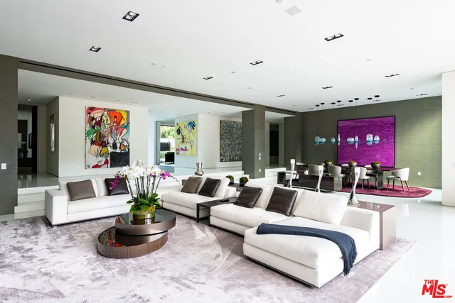 a living room with furniture potted plant and kitchen view