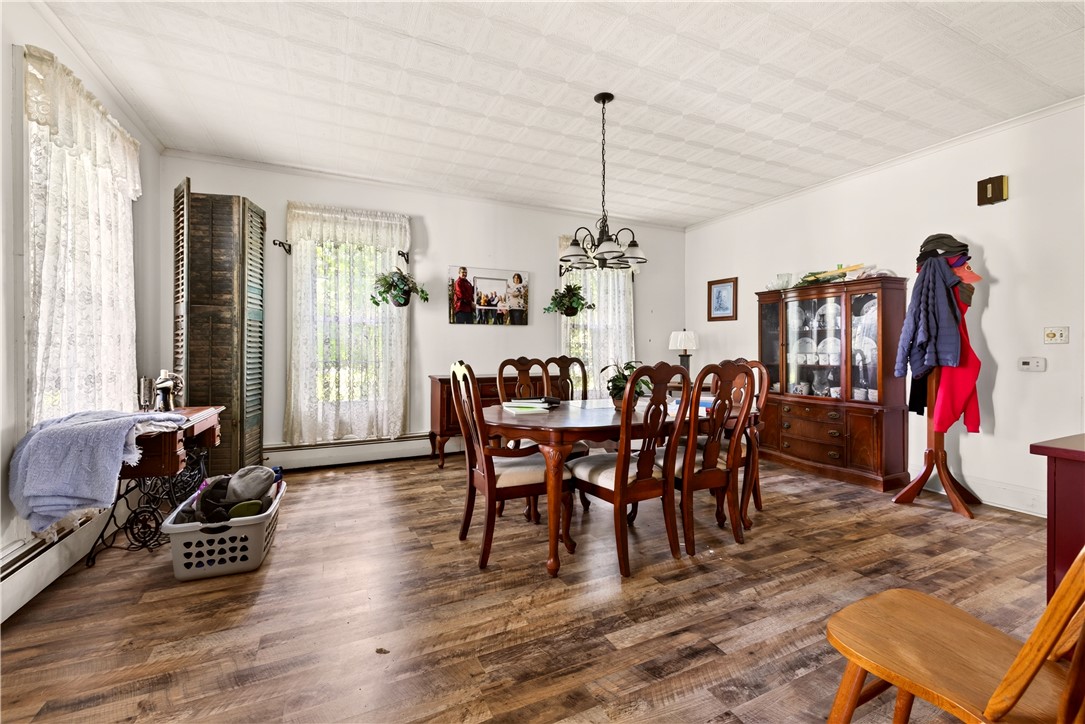 7780 Cold Springs Road Bath, NY 14810 - Photo 9 of 50 Gleaming wood-look floors anchor this spacious dining area beneath a textured ceiling.