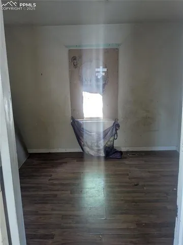 a view of a room with wooden floor and a window