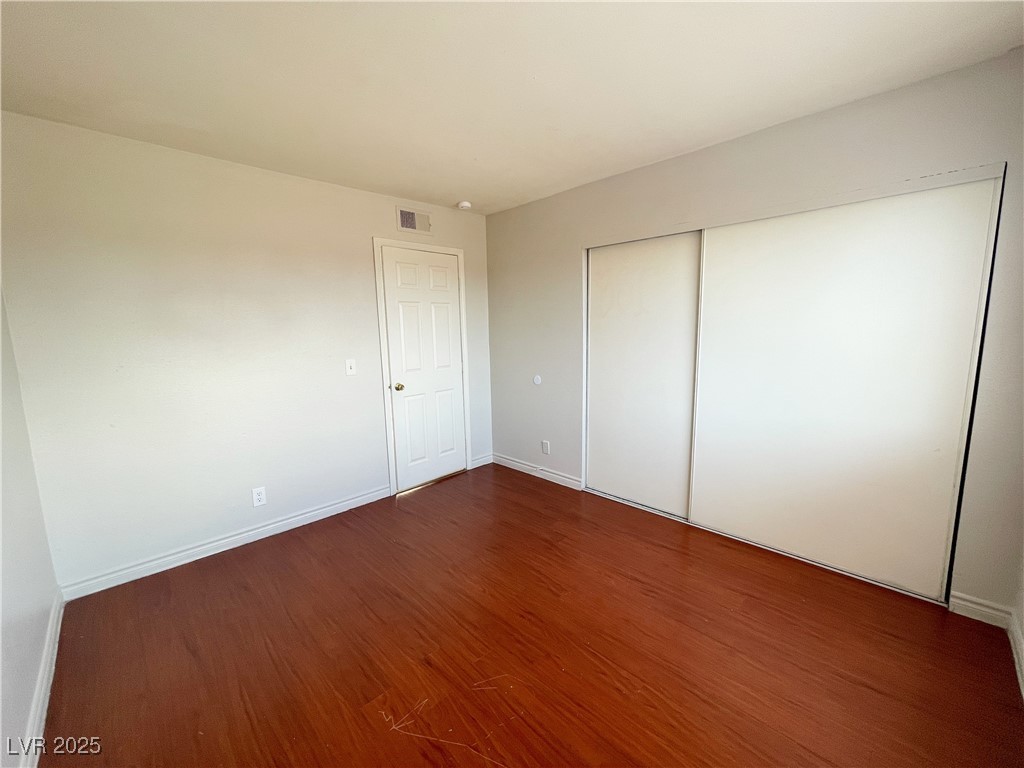 5447 Retablo Avenue, Unit 4 Las Vegas, NV 89103 - Photo 11 of 16 Unfurnished bedroom with wood finished floors and a closet
