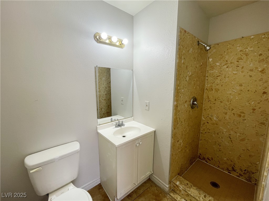 5447 Retablo Avenue, Unit 4 Las Vegas, NV 89103 - Photo 16 of 16 Full bath with a tile shower, vanity, and tile patterned floors