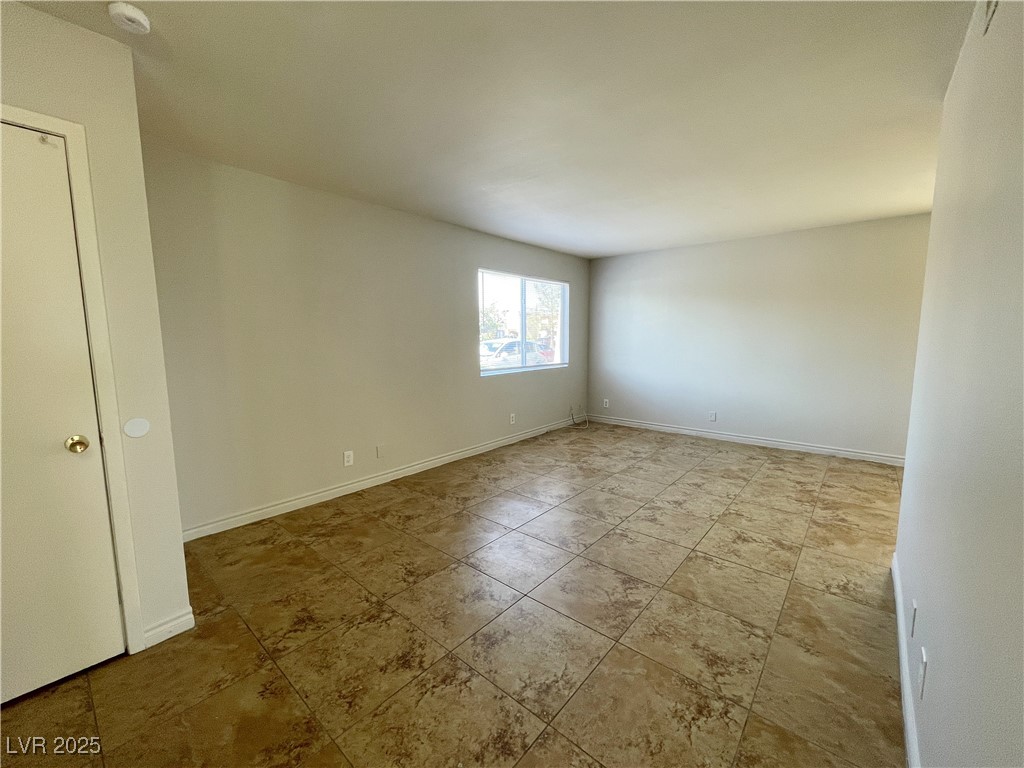 5447 Retablo Avenue, Unit 4 Las Vegas, NV 89103 - Photo 2 of 16 Empty room with baseboards and a smoke detector