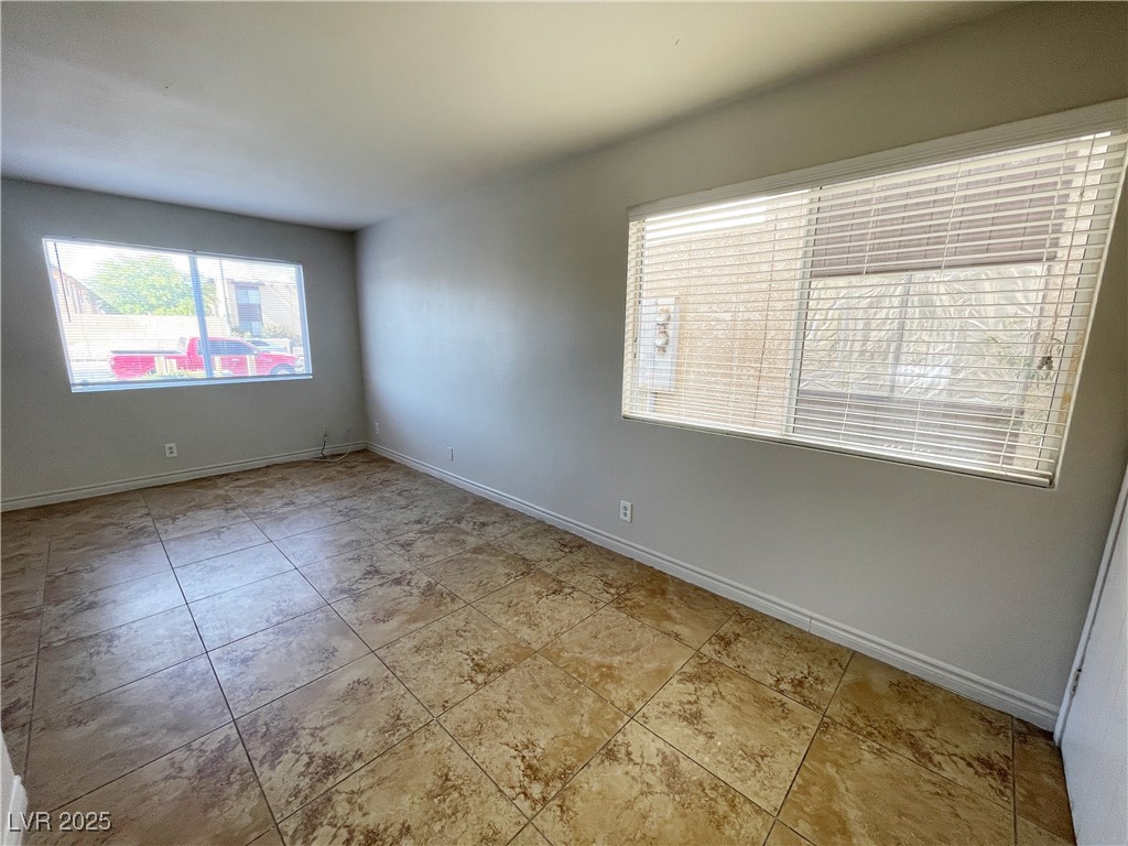 5447 Retablo Avenue, Unit 4 Las Vegas, NV 89103 - Photo 6 of 16 Spare room with baseboards and tile patterned floors