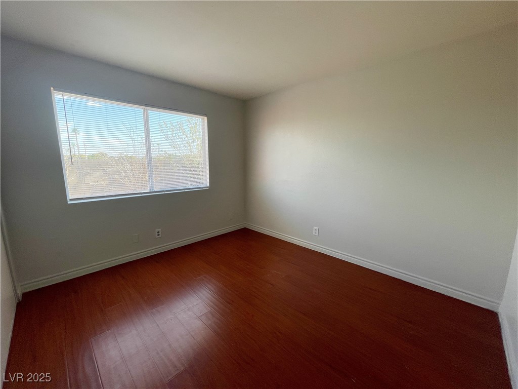 5447 Retablo Avenue, Unit 4 Las Vegas, NV 89103 - Photo 9 of 16 Unfurnished room with dark wood-style floors and baseboards
