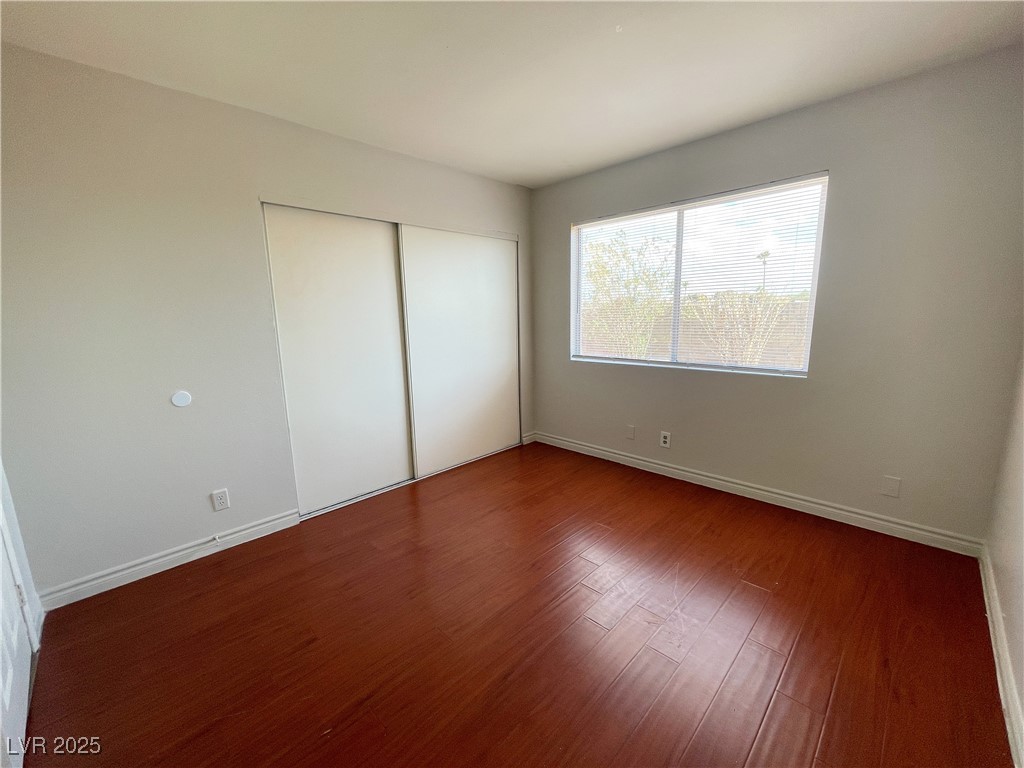 5447 Retablo Avenue, Unit 4 Las Vegas, NV 89103 - Photo 10 of 16 Unfurnished bedroom featuring wood finished floors and a closet