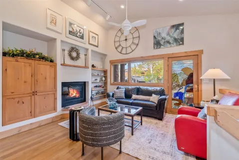 a living room with furniture a fireplace and a large window
