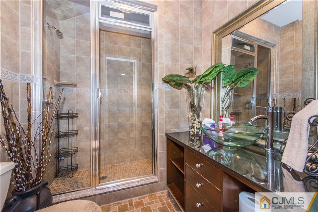 16 Ron's Edge Road Springfield, NJ 07081 - Photo 18 of 25 a bathroom with a glass shower door and a mirror