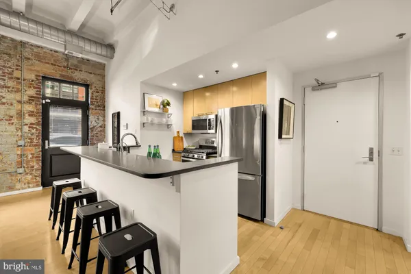 a kitchen with stainless steel appliances kitchen island granite countertop a refrigerator and a stove top oven