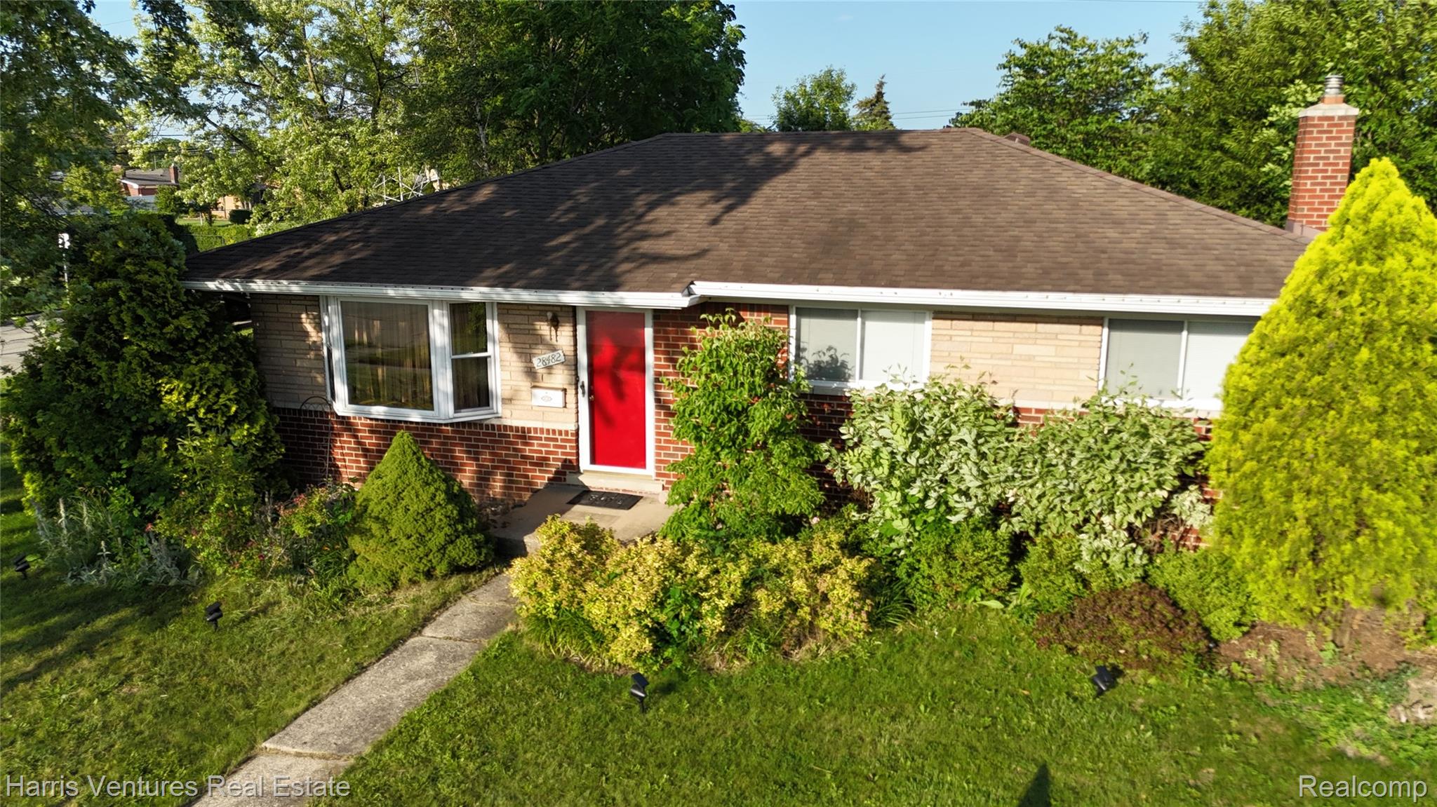 28482 Sutherland Avenue Warren, MI 48088 - Photo 3 of 25 Brick and siding exterior featuring a prominent red entry door and a shingle roof