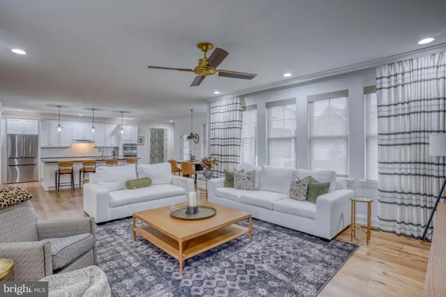 a kitchen with stainless steel appliances a dining table chairs and wooden floor