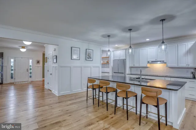 a kitchen with granite countertop white cabinets and stainless steel appliances